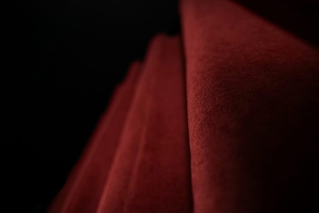 Gros plan sur les plis du rideau rouge en velours