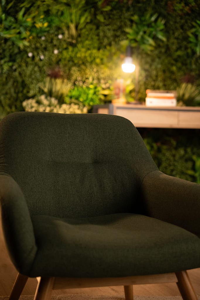 Zoom sur le tissu du fauteuil vert, soulignant la texture et la qualité des matériaux.