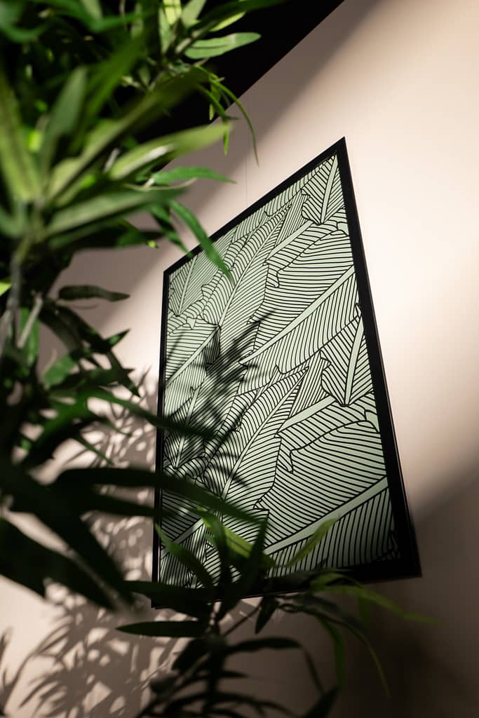 Cadre graphique végétal vu à travers les feuilles d’une plante, ambiance lumineuse et design.