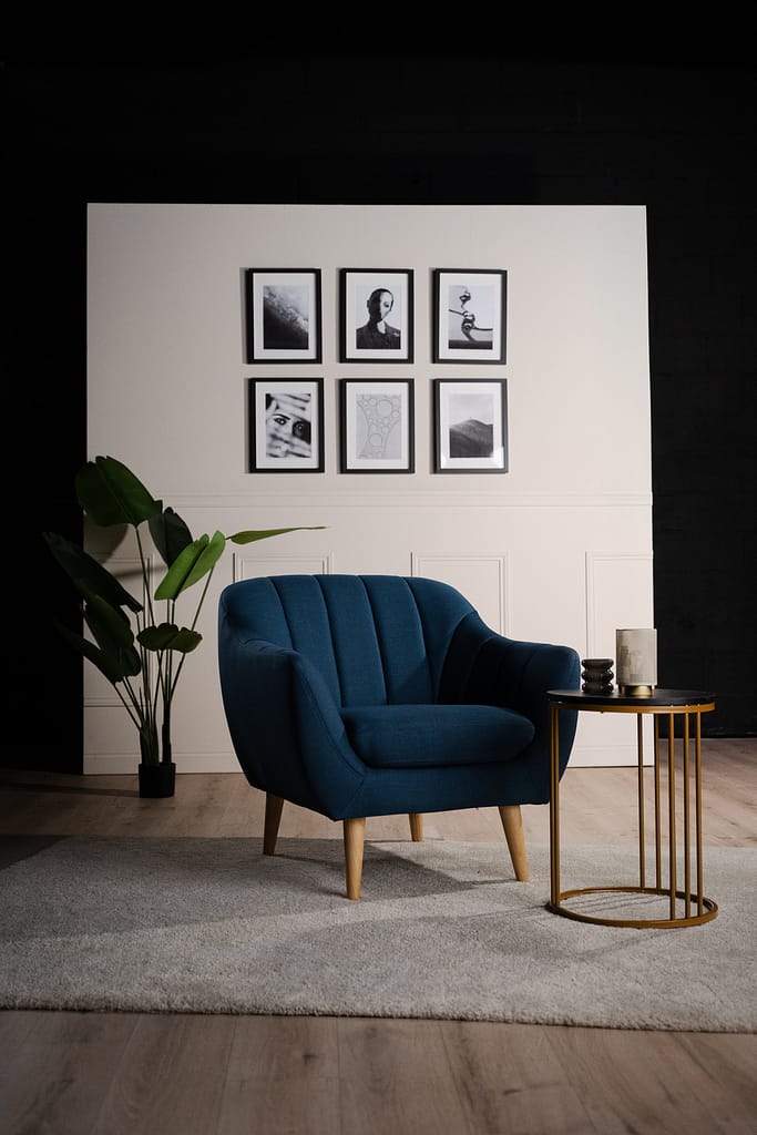 Vue large du décor La Parenthèse avec fauteuil et table sur un tapis gris